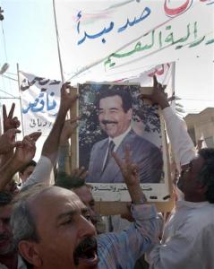 Protesters carry banners and a poster of the former Iraqi leader Saddam Hussein as they rally against the new constitution, in Baqouba, 60 kilometers (35 miles) northeast of Baghdad, Friday, Aug. 26, 2005. In the predominantly Sunni city of Baqouba, about 5,000 people rallied to protest against the proposed charter. Demonstrators carried photos of Saddam Hussein _ the first time they have been seen in public since the former dictator was arrested in December 2003.